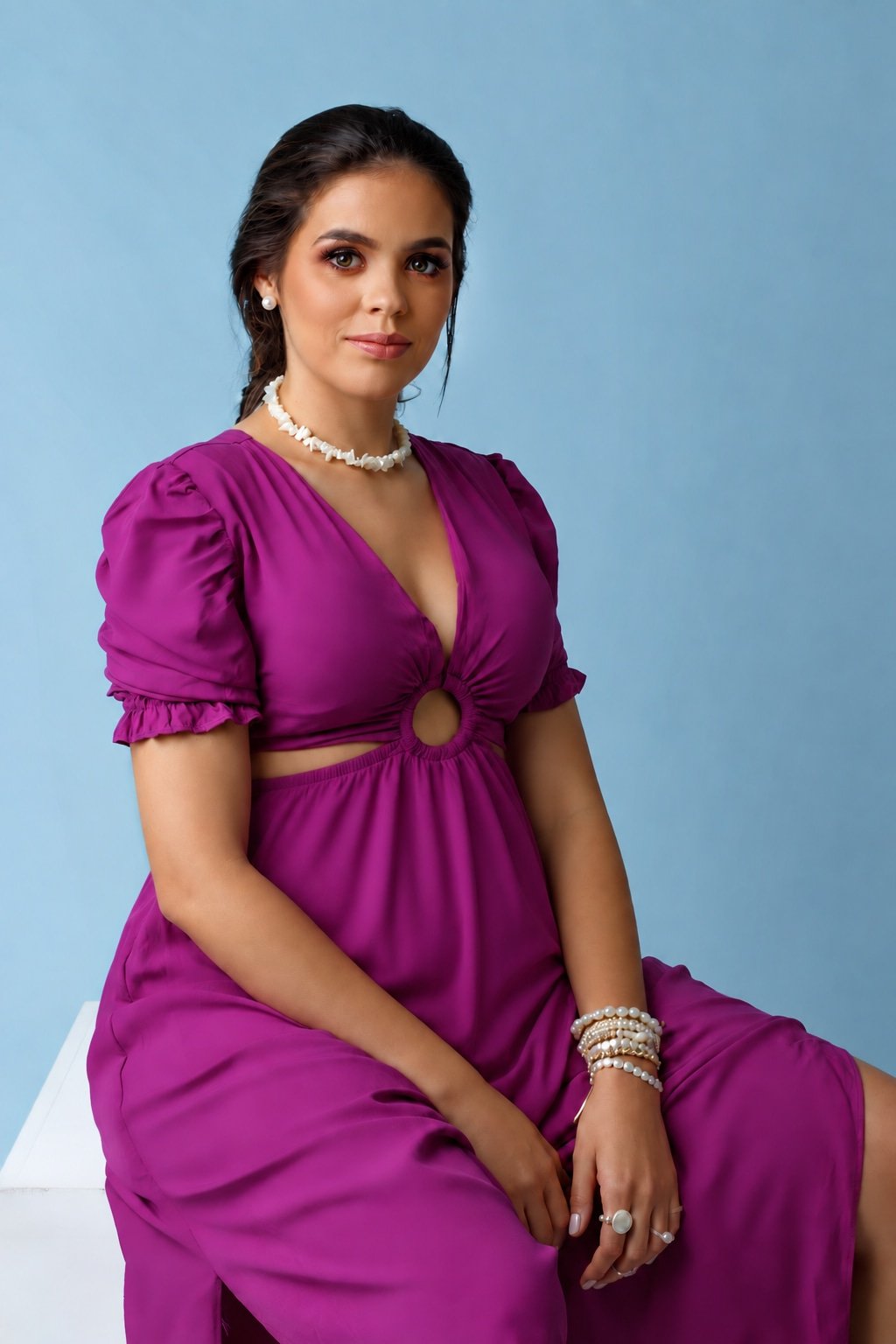 Ana sentada, em retrato de estúdio com vestido roxo e colar de pérolas.